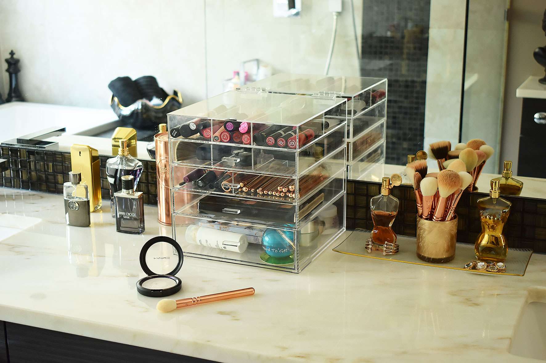 bathroom marble countertop with makeup ad perfume displayed on top