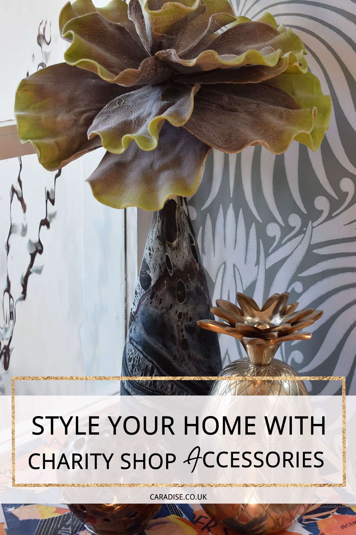 artificial stem in black marble vase next to gold pineapple ornament 