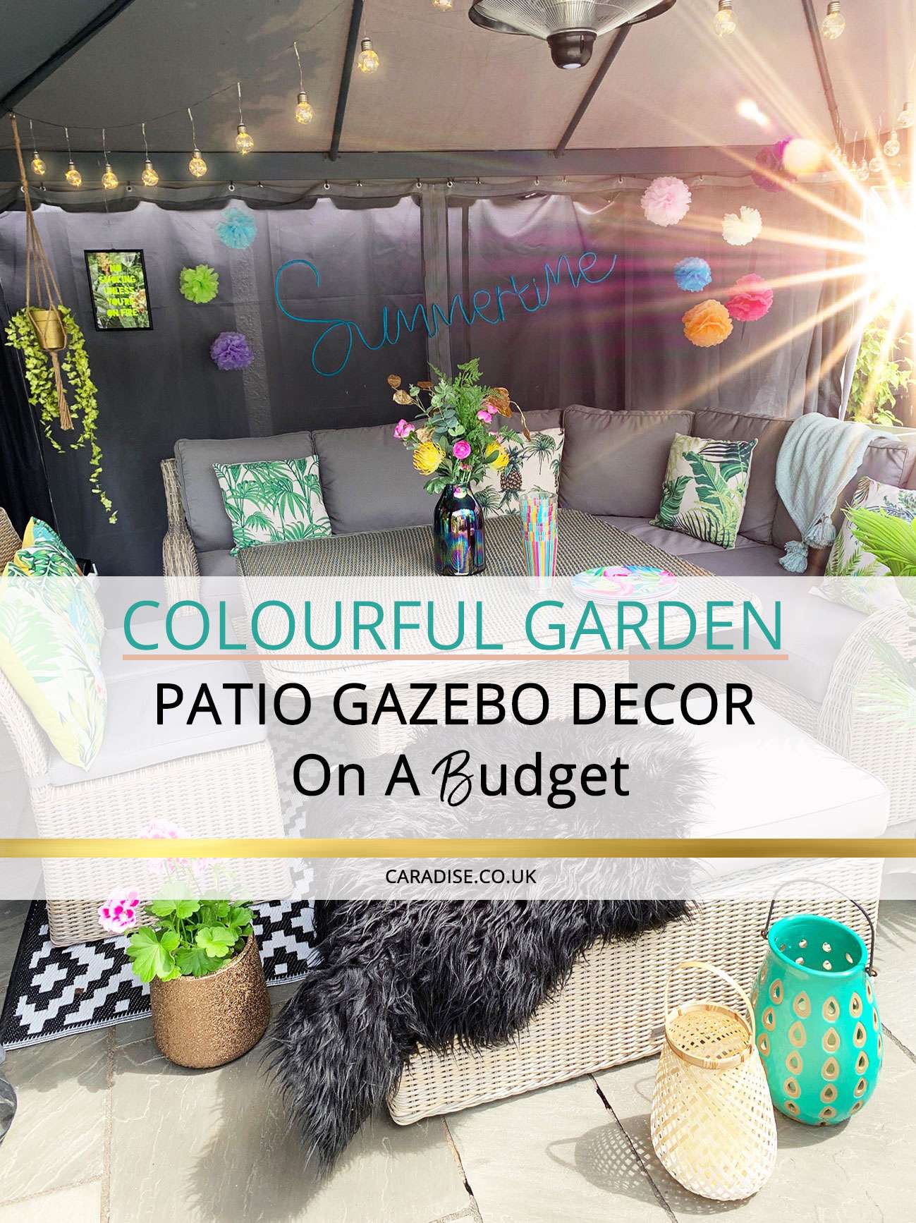 Patio table and chairs under a fabric gazebo decorated with colour pompoms, festoon lights, plants, tropical cushions and lanterns with flamingo plates and cups on the table with text overlay.