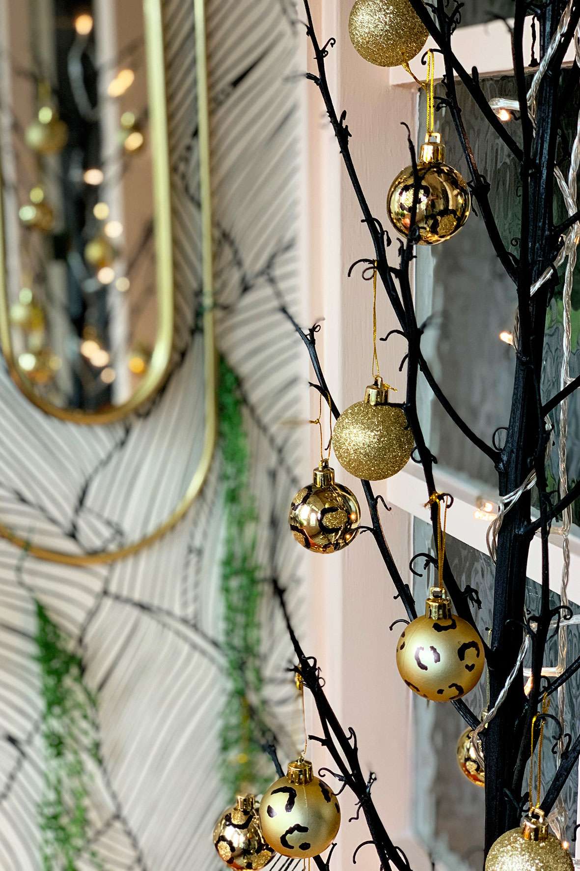 Gold leopard print Christmas baubles hanging on a black tree
