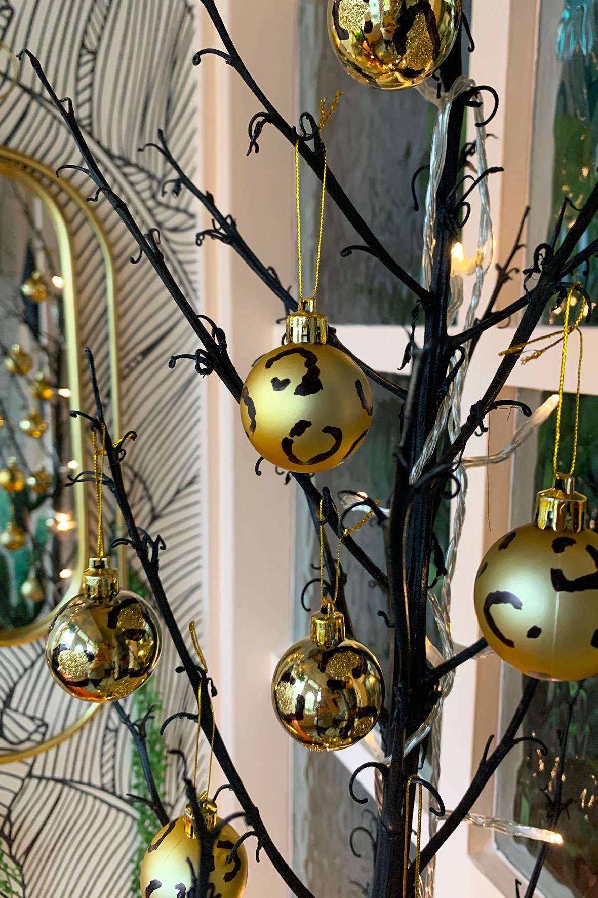 Gold leopard print Christmas baubles handing on a black tree