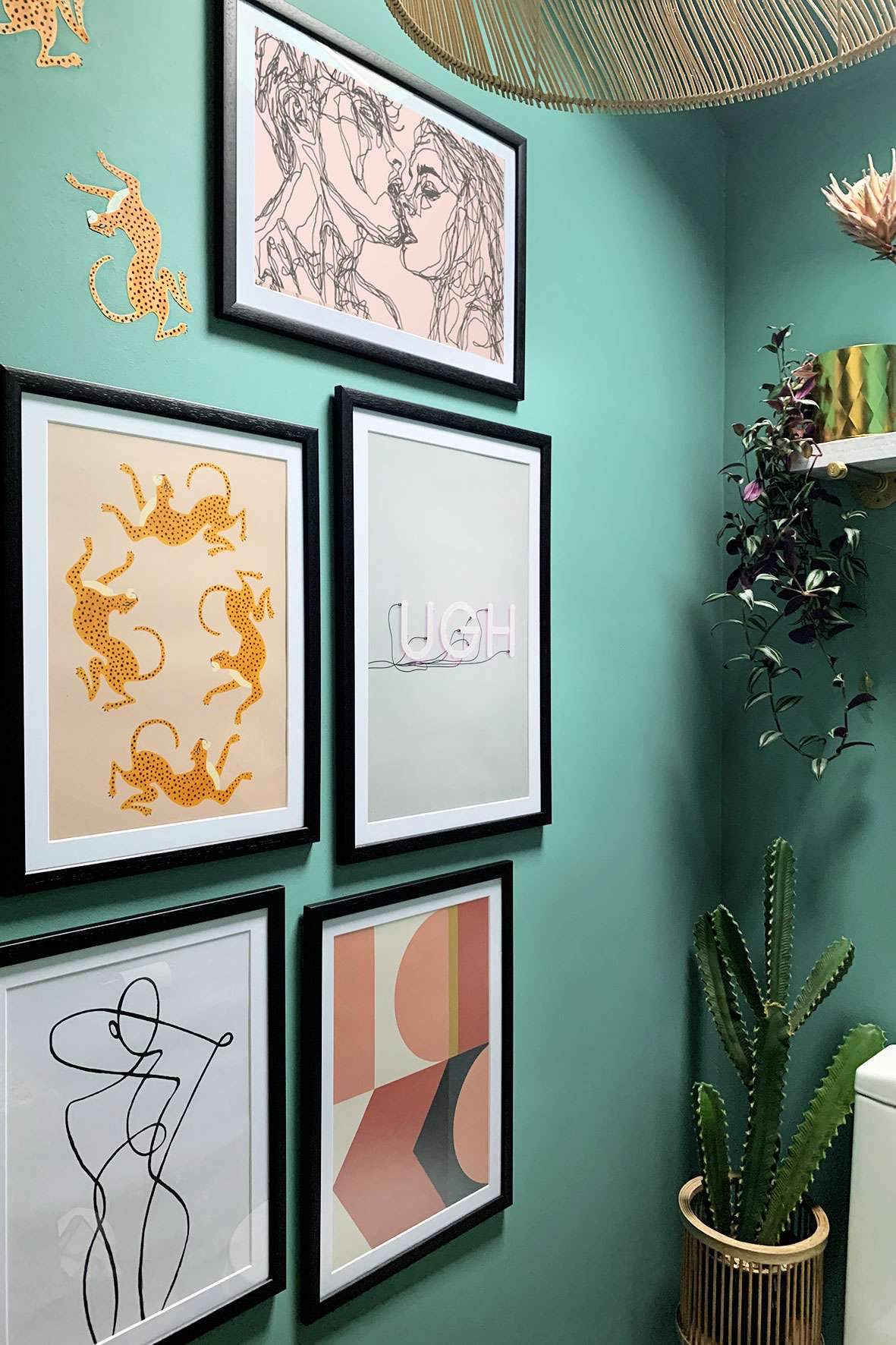 Picture gallery on teal wall.