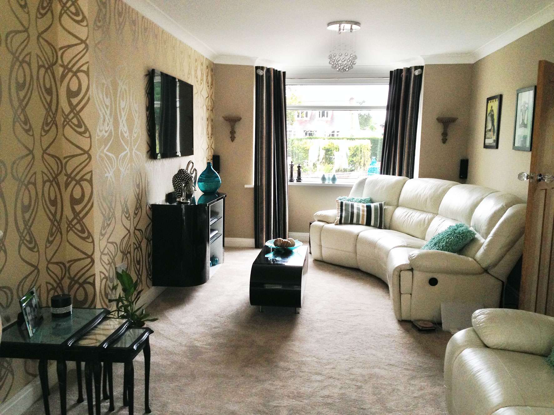 living room with beige carpet and sofa and black striped curtains
