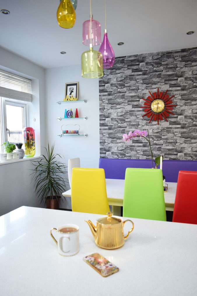 colourful dining area with teapot and cup of tea on quartz island.