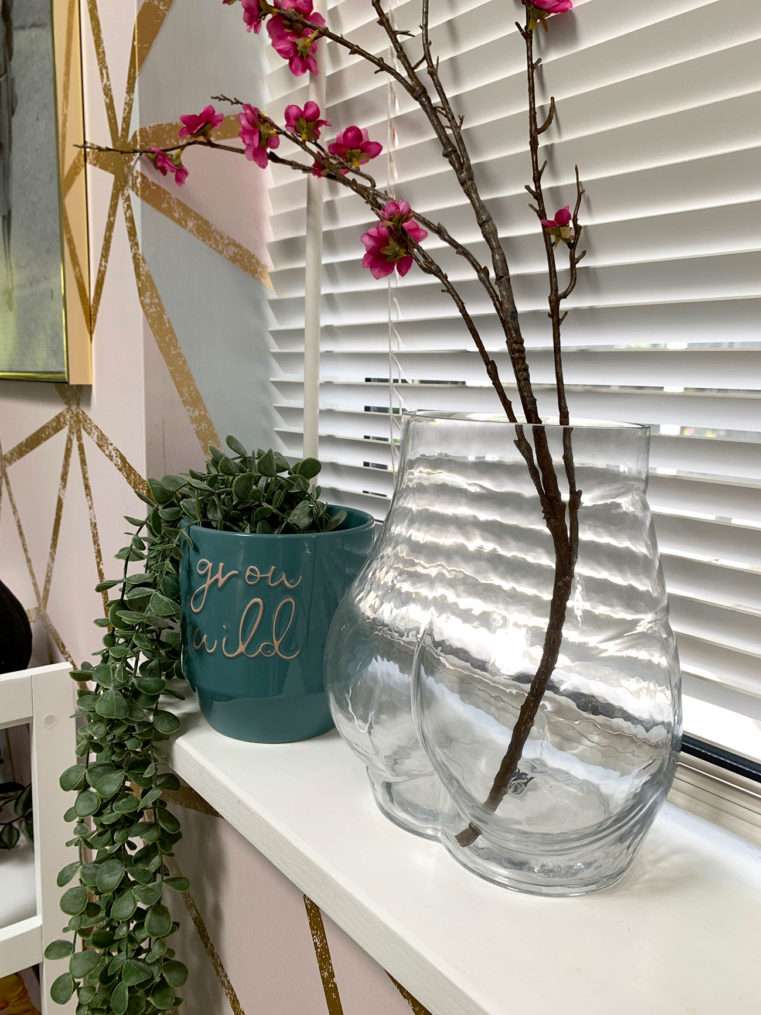 bottom shaped clear glass vase and teal planter on windowsill