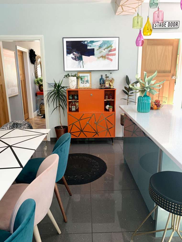 kitchen area with teal, blush, and orange decor and geometric pattern.