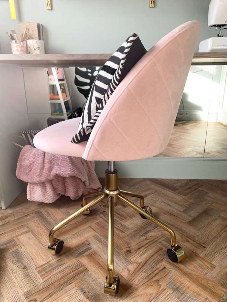 Blush velvet swivel chair with brass legs.