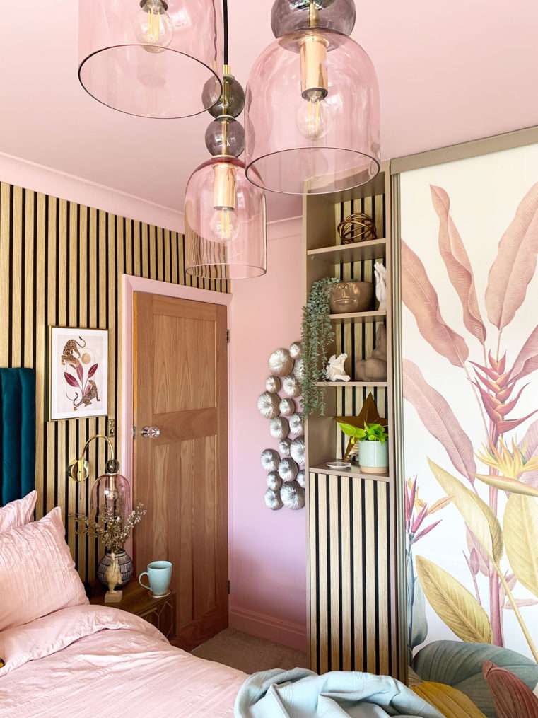 Bedroom corner with oak door, wood slat wall and shelves, and tropical mural wardrobe door.