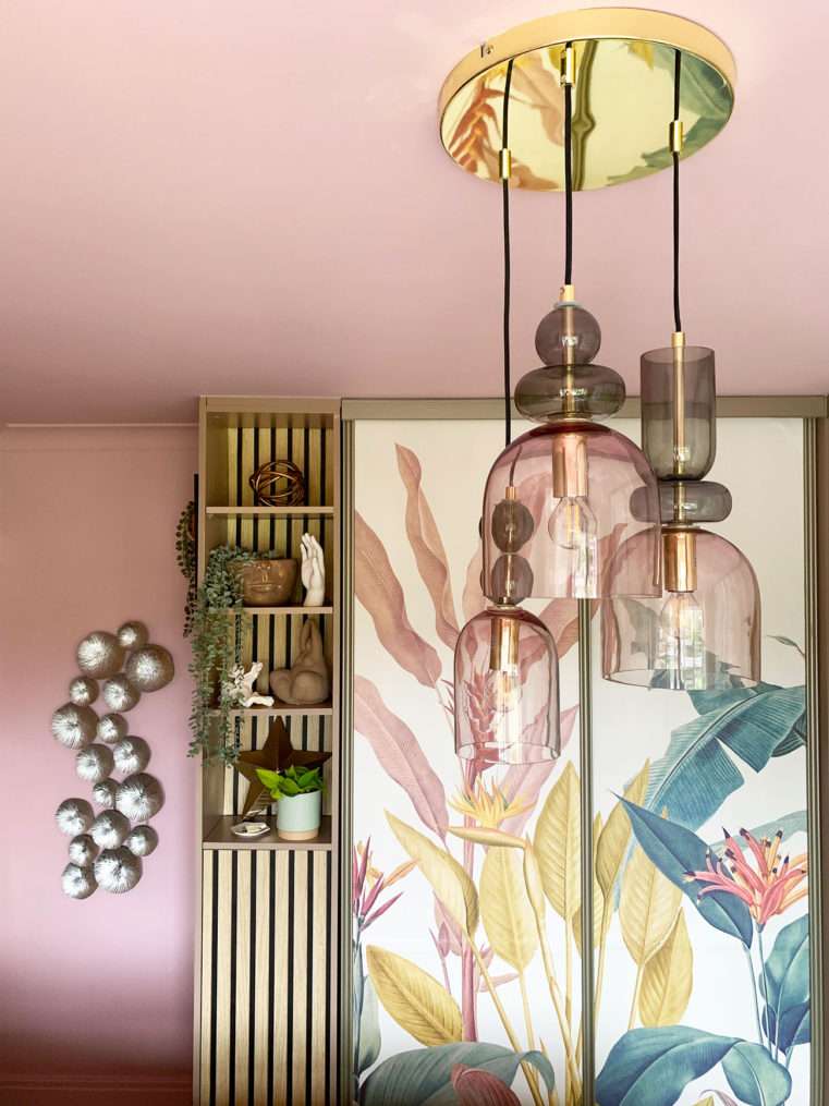 Glass blush and sage triple light fitting infant of tropical wardrobe mural and quirky styled shelf.
