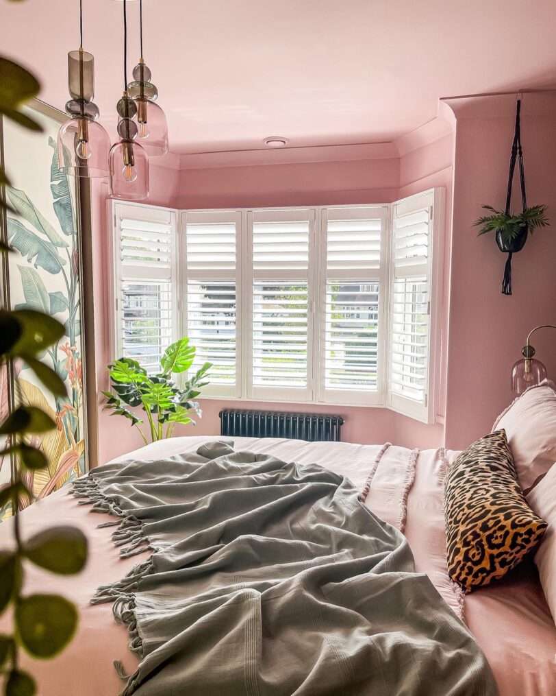 Pink bedroom with plantation and blush pink bedding.